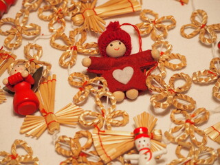 wooden Christmas figurines of red and white color, fabric red elf, stick figures and winter motifs, straw holiday decorations