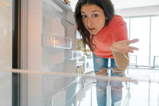 The Girl Is Surprised At The Empty Refrigerator. Lack Of Food. Food Delivery