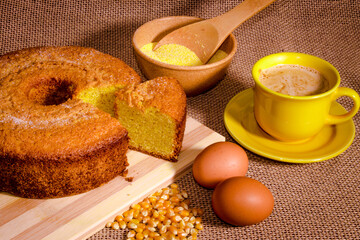 Brazilian corn cake made with a type of corn flour (Fuba) on the wood table and flour on the spoon and cinnamon. top view .generally typic in northeast of brazil. founded in traditional party .