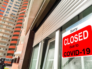 Business center closed due to COVID-19, sign with sorry in door window. Stores, restaurants,...