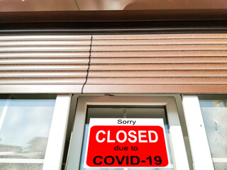 Business center closed due to COVID-19, sign with sorry in door window. Stores, restaurants,...
