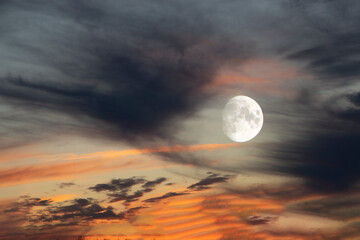 The photo shows a dramatic evening sky with moon