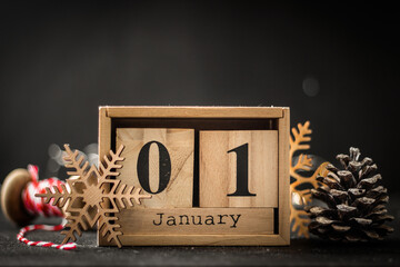 Macro shot of the wooden calendar of blocks with the date of January the first on the black...