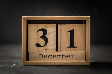 Closeup of the wooden calendar of blocks with the date of December 31 on the black background. New...
