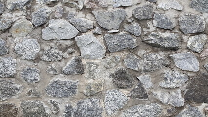 Granite masonry. Wall of granite stones. Vintage background