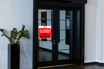 Business center closed due to COVID-19, sign with sorry in door window. Stores, restaurants, offices, other public places temporarily closed during coronavirus pandemic. Economy hit by corona virus