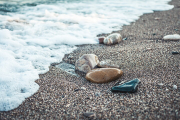 Fototapeta na wymiar Waves hitting sea shore. coast line with rocks and pebbles