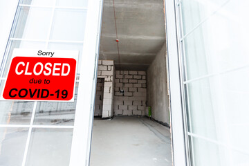 Business center closed due to COVID-19, sign with sorry in door window. Stores, restaurants,...