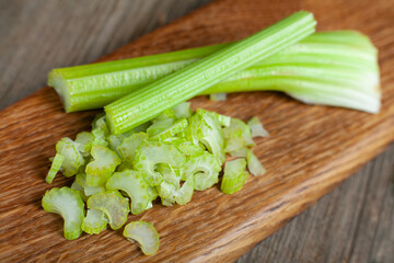 Sliced fresh celery closeup. Celery stalk on cutting wooden board.