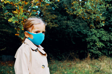 Girl in an antivirus mask in the autumn park.