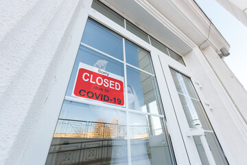 Business center closed due to COVID-19, sign with sorry in door window. Stores, restaurants,...