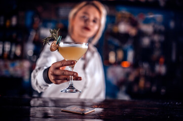 Girl bartender creates a cocktail on the porterhouse