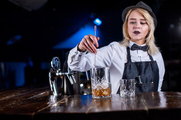 Girl barman mixes a cocktail at the porterhouse