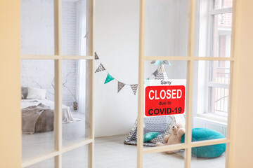 Business center closed due to COVID-19, sign with sorry in door window. Stores, restaurants,...