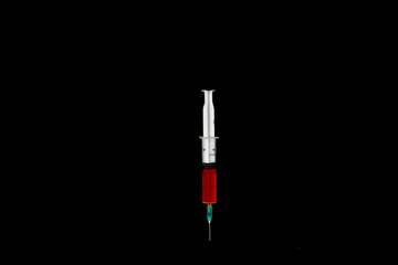 Syringe with coronavirus vaccine on black background