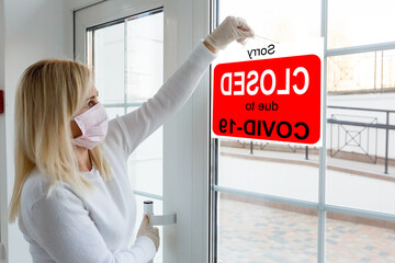 Business center closed due to COVID-19, sign with sorry in door window. Stores, restaurants,...