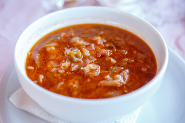 A Cup of borscht made from potatoes, vegetables and meat. Close up