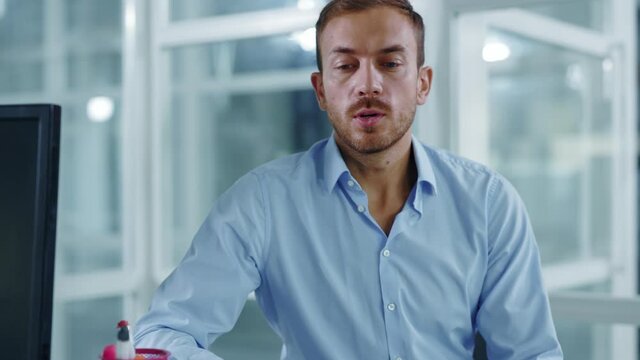 Tired sad young man sitting at table in medical office speaking with woman doctor looking at x-ray scan of lunges during consultation. Close up. Slow motion