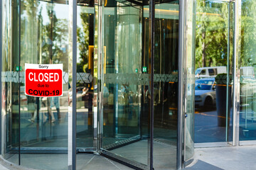 Business center closed due to COVID-19, sign with sorry in door window. Stores, restaurants,...