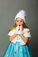 Little cute girl in a white hat on a gray background