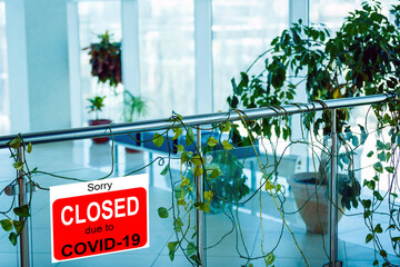 Business center closed due to COVID-19, sign with sorry in door window. Stores, restaurants,...