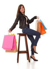 Beautiful girl on a chair with purchases in her hands after shopping. Beautiful woman with shopping after Black Friday. 