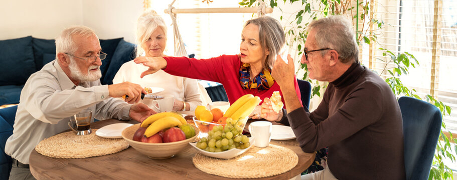 Group Of Senior People Eating Dessert During A Meeting