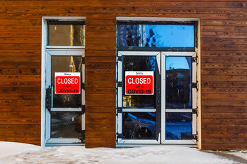 Business center closed due to COVID-19, sign with sorry in door window. Stores, restaurants,...