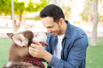 Latin man making eye contact with his cute dog