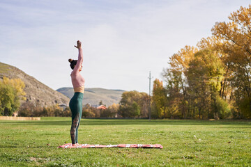 Woman practicing yoga in the park - relaxing in nature