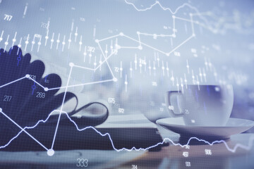 Double exposure of financial chart drawing and desktop with coffee and items on table background....