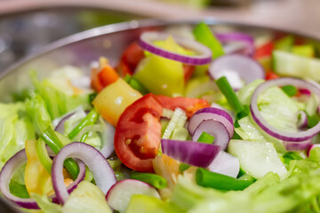 fresh salad of vegetables tomatoes, lettuce, and red onion rings close-up