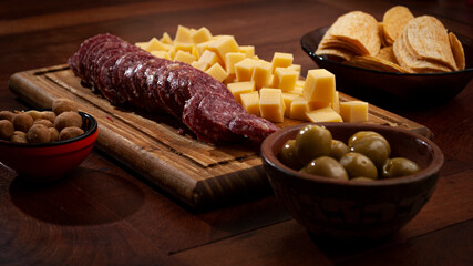 assorted mincemeat on a wooden table. catering, sausage, cheese, olives, peanuts, french fries,
