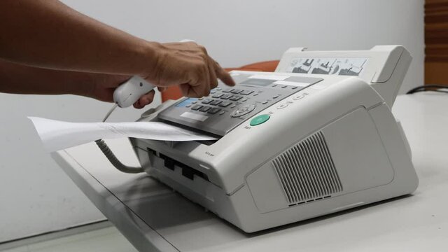 hand man are using a fax machine in the office, equipment for data transmission.