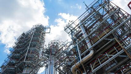 Fototapeta premium Petrochemical refinery plant. Industrial towers at oil refinery. Oil refinery twilight on classic blue sky background.. Space for text. Design concept.