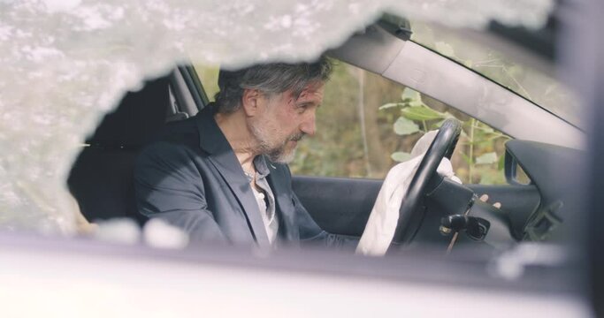 Skinny mature man inside broken car