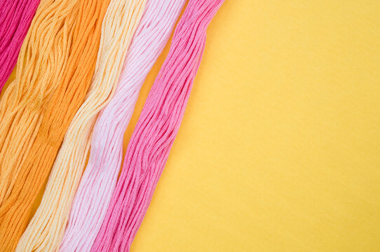 Top view of colorful mouline threads isolated on a yellow background