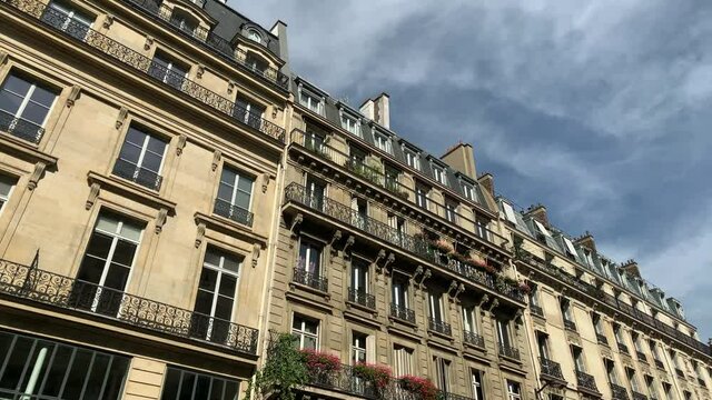 Footage of historical, traditional, typical buildings showing French / Parisian architecture style in Paris. It is a sunny summer day. Camera moves forward.