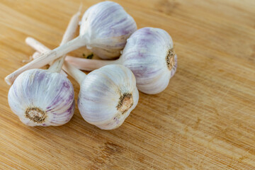 four white heads of garlic on a wooden surface close-up