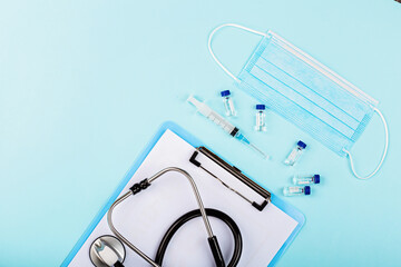 Flat lay of coronavirus covid-19 vaccine with syringe, face mask. Mockup with copy space, top view, overhead