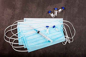 Flat lay of coronavirus covid-19 vaccine with syringe, face mask. Mockup with copy space, top view, overhead