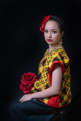 Mujer latina oaxaqueña con traje bordado a mano, collares y aretes de oroo, moño color rojo y...