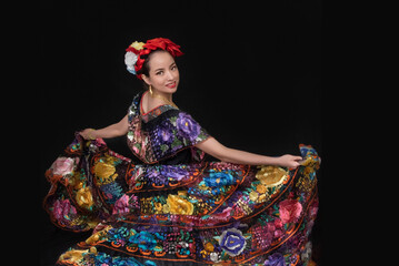 mujer chiapaneca con vestido floreado bordado a mano y rebozo naranja, bailando folklor mexicano de...