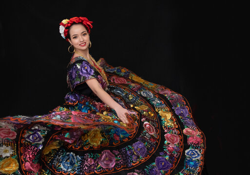 mujer chiapaneca con vestido floreado bordado a mano y rebozo naranja, bailando folklor mexicano de chiapas mexico, trenza en color rojo con cadenas de oro y artes dorados, una sonrisa marimba