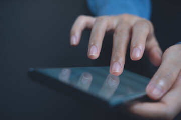 Close up of woman finger touching on mobile phone screen surfing the internet for online shopping