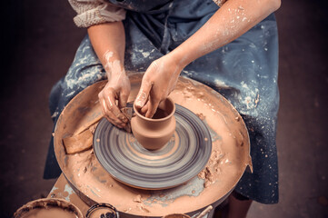 The potter works in the workshop. Hands and a potter's wheel close-up