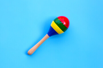 Wooden rattle on blue background.