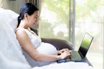 Beautiful happy and healthy asian pregnant business woman working from home, concept of stay home and safe work for high risk people group in covid 19 virus outbreak situation.