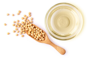 Soy bean oil in glass bowl and soybean in wooden spoon isolated on white background. Top view. Flat...