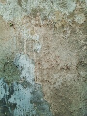 Brick wall. Old flaky white paint peeling off a grungy cracked wall. Cracks, scrapes, peeling old paint and plaster on background of old cement wall. An old cement stone wall as vintage cracked.